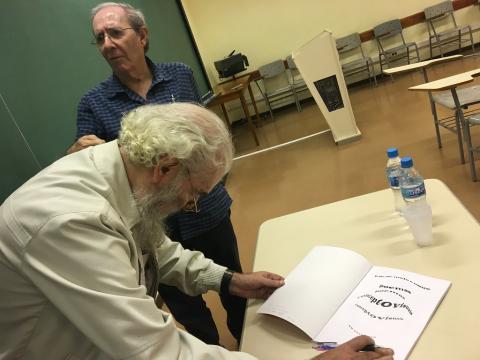 Benjamin Abdala Junior e o poeta autografando o livro. 